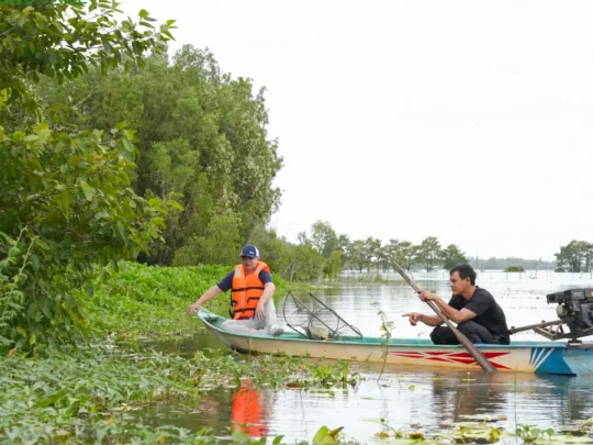 Tourists learning to pluck and arrange water lilies in Chau Doc