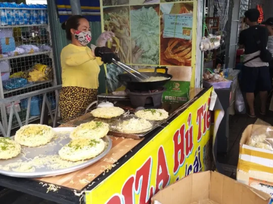 Crispy rice noodle pizza being prepared at a local workshop