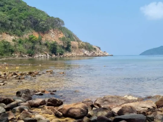 Rocky shoreline and tropical coastal landscape during Ong Cau Beach tour in Con Dao
