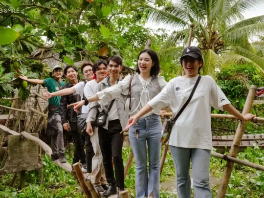 A person carefully crossing a traditional "monkey bridge," a fun and wobbly challenge on the Son Islet tour