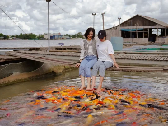 A person's expression of comfort and relaxation during a koi fish massage in a pond.