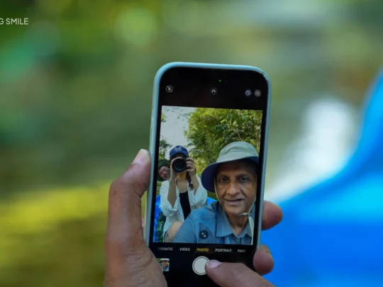 A tourist happily posing for a photo with the beautiful forest scenery