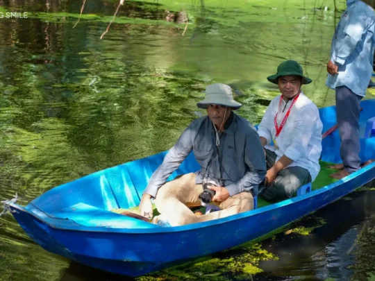 A tourist happily posing for a photo with the beautiful forest scenery