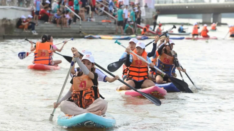 Participants wearing life jackets competing in a stand-up paddleboarding race in Can Tho