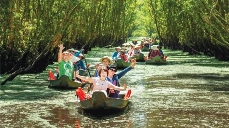Tourists enjoying Sustainable Tourism by rowing traditional boat in Mekong Delta