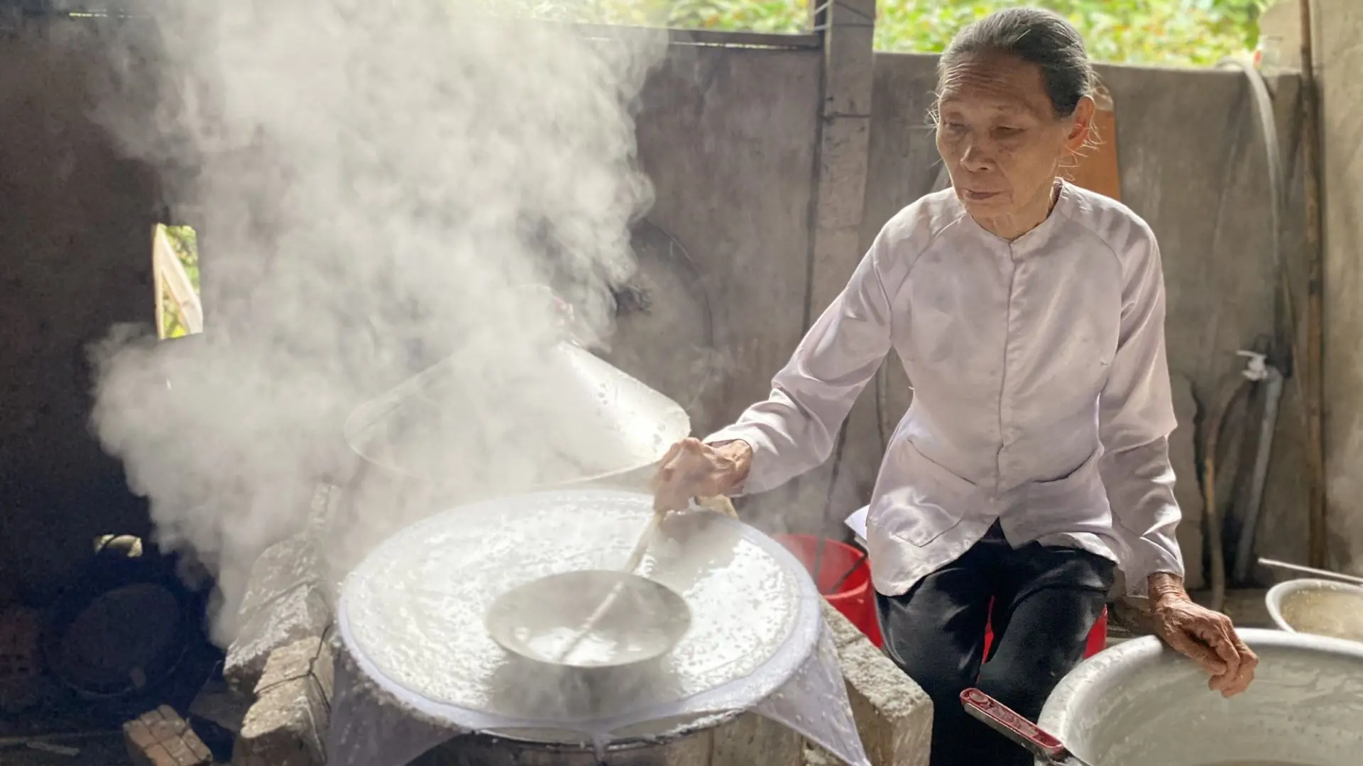 Steaming rice batter during the rice paper making process at Steaming rice batter during the rice paper making process at Thuan Hung Rice Paper Village