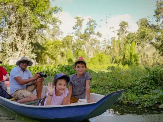 Young children looking excitedly at the nature of Tra Su Forest, their faces full of wonder
