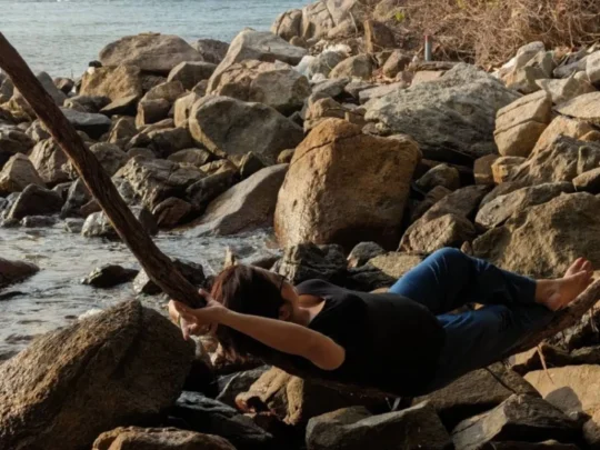 Traveler resting on rocky beach during Ong Cau Beach tour in Con Dao National Park