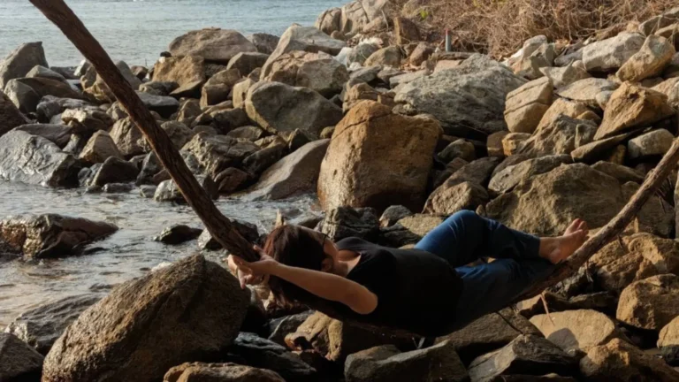 Traveler resting on rocky beach during Ong Cau Beach tour in Con Dao National Park