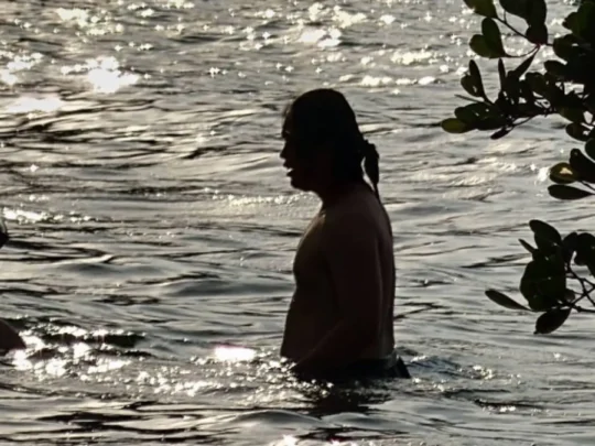 Travelers swimming at Ong Cau Beach Con Dao during sunset after forest hiking tour