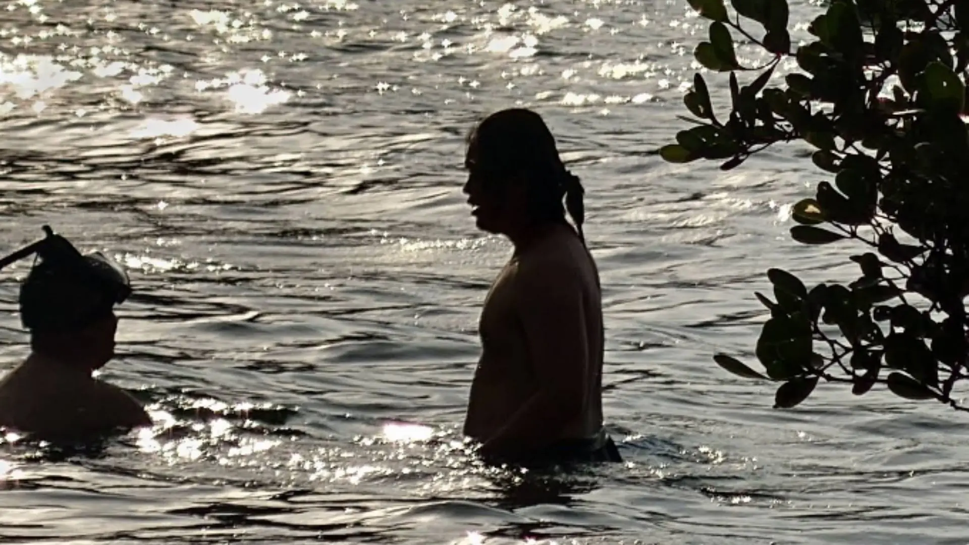 Travelers swimming at Ong Cau Beach Con Dao during sunset after forest hiking tour