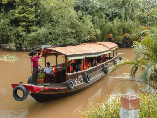 Navigating a narrow, lush green canal in Vinh Long on the Me Kong Smile boat tour