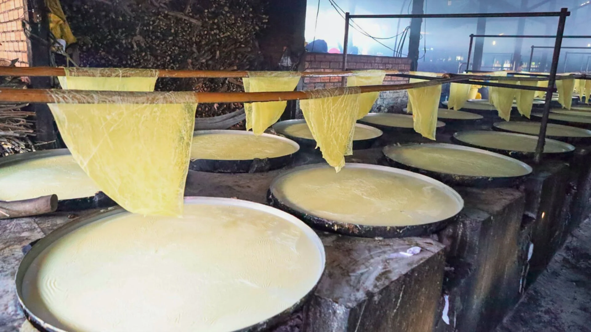Sheets of fresh tofu skin hanging to dry in the traditional method at a Vinh Long workshop
