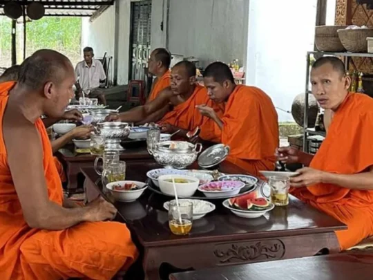 Monks in traditional saffron robes performing a ceremony at Phu Ly Pagoda for guests of the Me Kong Smile tour
